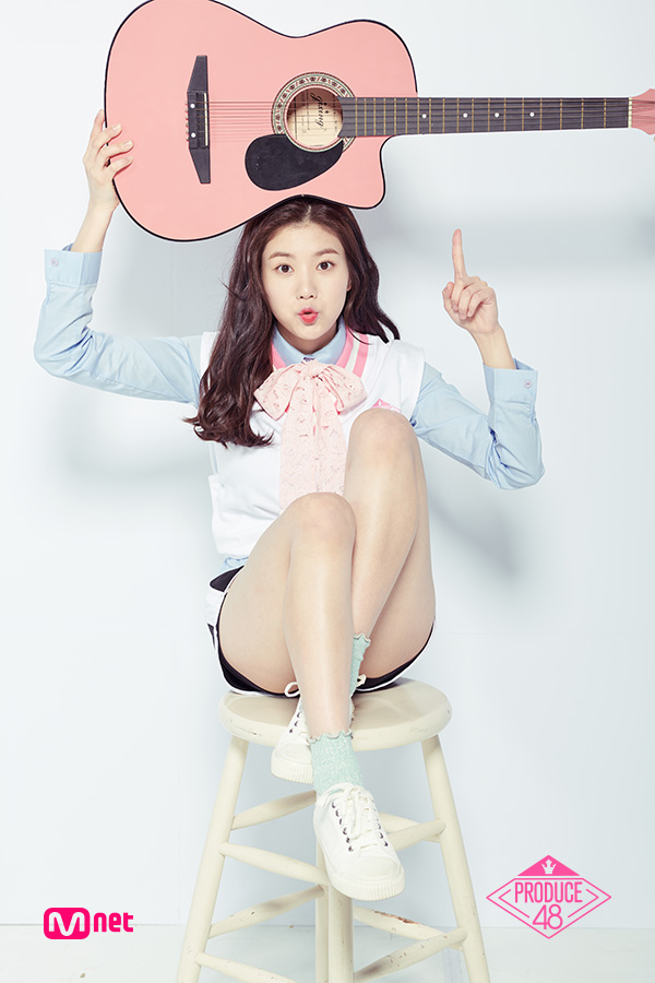Tags: Television Show, K-Pop, Kwon Eunbi, Pointing, White Footwear, Shorts, Blue Shirt, Sitting On Chair, Musical Instrument, Bow Tie, Text: Series Name, Shoes